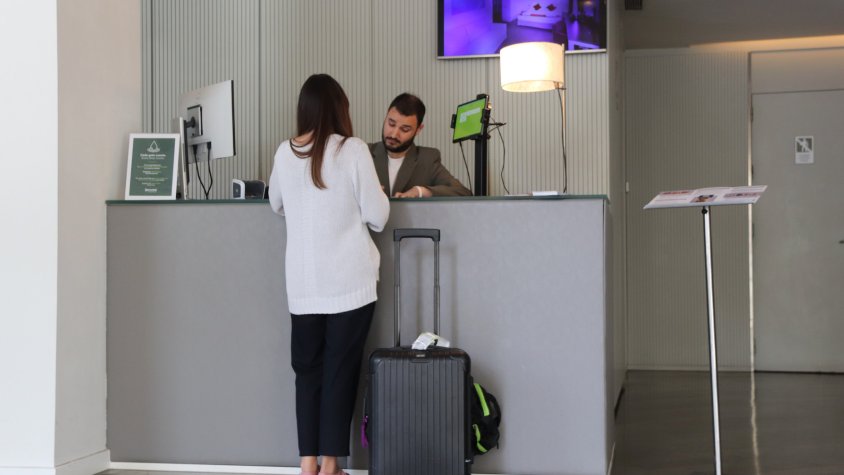 Un turista a la recepció d'un hotel