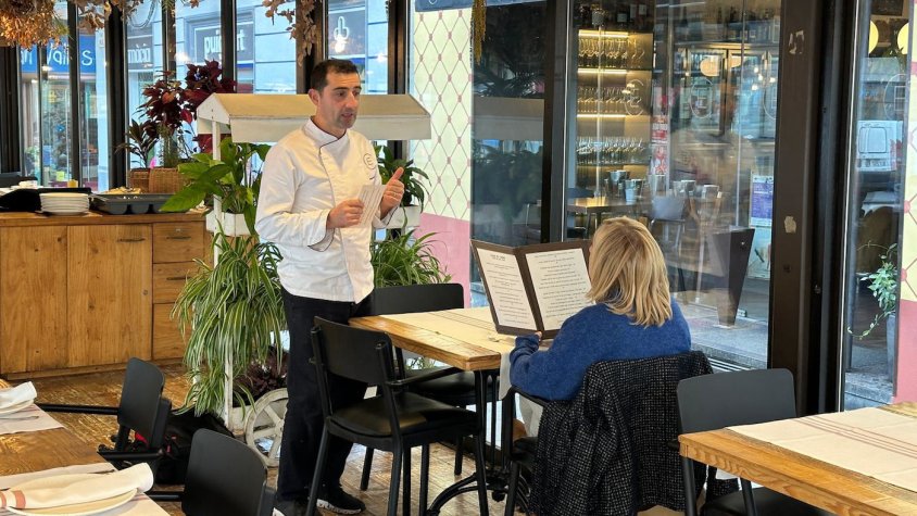 Un cambrer pren nota a una clienta a un restaurant