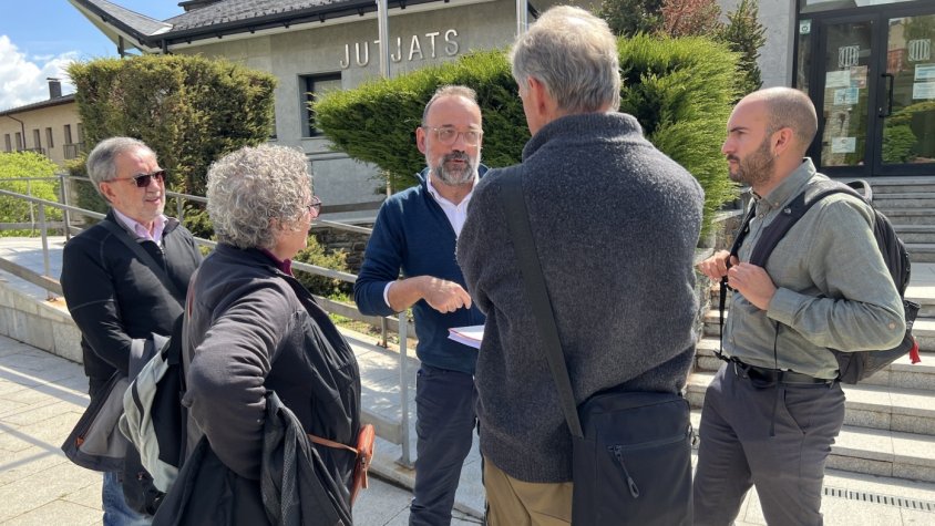 L'advocat Benet Salellas, amb diversos membres de l'entitat SOS Pirineus, entre ells la seva portaveu, Núria Martí, davant dels jutjats de Puigcerdà en el dia que ha declarat el president del Consell Comarcal de la Cerdanya, Isidre Chia